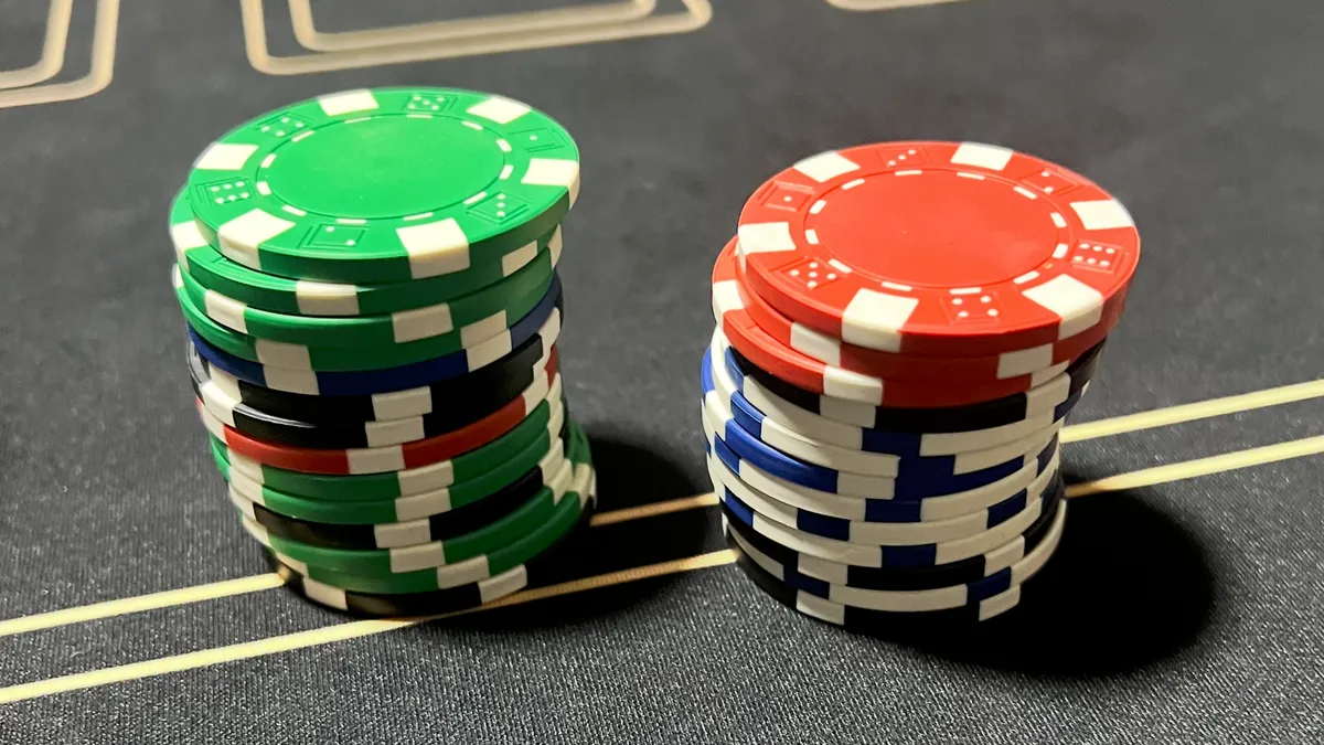 Two stacks of mixed-denomination poker chips on a grey felt table